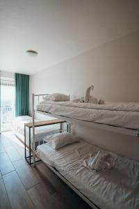 a room with three bunk beds and a window at Appartement Val Rose II, 11de verdieping in Blankenberge