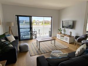 a living room with a couch and a table at Reflections on the water in Port Macquarie