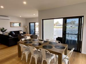 a living room with a wooden table and chairs at Reflections on the water in Port Macquarie