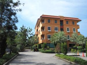 un bâtiment orange avec beaucoup d'arbres et de buissons dans l'établissement I-Home Residence and Hotel, à Pluak Daeng