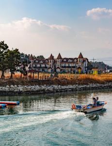 a small boat in the water in front of houses at Santa Beach Pension in Gangneung
