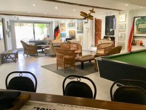 a living room with a pool table and furniture at Oceangolf Guest House in Noordhoek