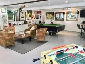 a billiards room with a pool table and chairs at Oceangolf Guest House in Noordhoek