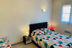 a bedroom with a bed with a colorful comforter at Appartement Vue Mer - 6 personnes in Cerbère