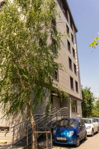 a blue car parked in front of a building at 7 days hotel in Almaty