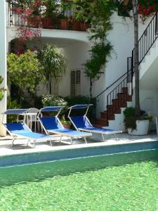 two blue lounge chairs sitting next to a swimming pool at Hotel la Maggioressa in Ischia