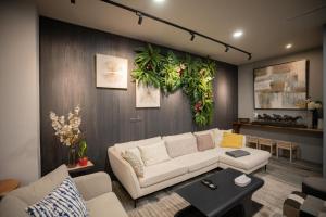 sala de estar con sofá blanco y plantas en la pared en HUA B&B, en Hengchun