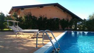 a swimming pool with a bench next to a house at Residence Boschetti in Manerba del Garda