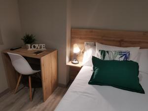 a bedroom with a bed and a desk with a green pillow at Km101 in Baamonde
