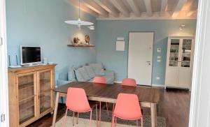 une salle à manger avec une table et des chaises roses dans l'établissement Light Blue apartment, à Peschiera del Garda