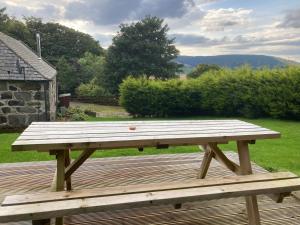 a wooden picnic table sitting on top of a deck at Woodside Steading in Huntly