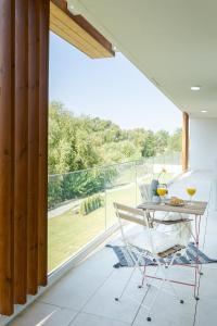 een tafel en stoel op een balkon met uitzicht bij Il Lago - Turquoise - Cozy Luxurious Smart Home By The Lake in Voluntari