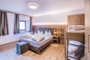 two beds in a room with wooden walls at Apartments Heidenberger Delle Scuole in Colle Isarco
