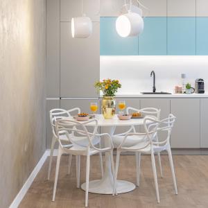 una cucina con tavolo e sedie bianchi di Il Lago - Turquoise - Cozy Luxurious Smart Home By The Lake a Voluntari