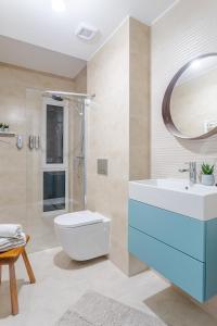 un bagno con lavandino, WC e specchio di Il Lago - Turquoise - Cozy Luxurious Smart Home By The Lake a Voluntari Altre 26 foto