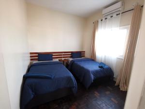 two beds in a room with a window at TD Guest House 4 Plus in Chimoio