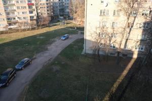dois carros estacionados numa estrada ao lado de um edifício em Vienības 32 em Daugavpils