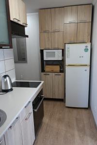 uma cozinha com um frigorífico branco e armários de madeira em Vienības 32 em Daugavpils