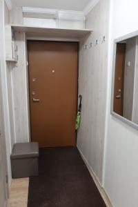 a hallway with a brown door and a trash can at Vienības 32 in Daugavpils