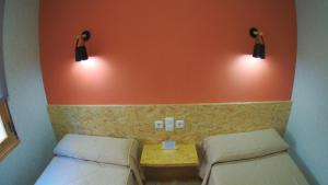 a room with two beds and two lights on the wall at Hs San Francisco - CÉNTRICO in Almagro