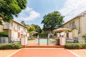 uma piscina no pátio de uma casa com uma cerca em Courtyard Hotel Arcadia em Pretoria