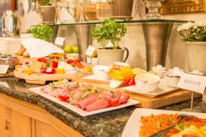 a buffet with several plates of food on a counter at Courtyard Hotel Arcadia in Pretoria