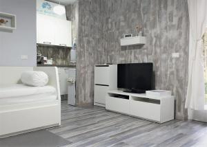 a living room with a television on a white cabinet at Azur Apartment Sirmione in Sirmione