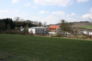a large field with houses in the background at Hotel Wilhelmshöhe in Neuenrade