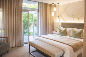 a bedroom with a large bed and a large window at The Windhoek Luxury Suites in Windhoek