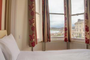 a bedroom with a bed and a window with a view at Baytree Hotel in Llandudno