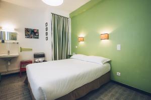 sypialnia z dużym białym łóżkiem w zielonej ścianie w obiekcie Chez Marie w mieście Linguizzetta