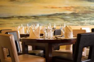 a wooden table with wine glasses and napkins on it at Baytree Hotel in Llandudno