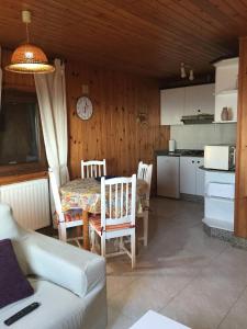 a living room with a table and a kitchen at Bungalow 2 (adosado) - Playa Arnela in Carballo