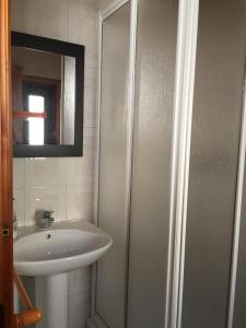 a white bathroom with a sink and a mirror at Bungalow 2 (adosado) - Playa Arnela in Carballo