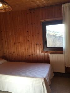 a bed in a wooden room with a window at Bungalow 2 (adosado) - Playa Arnela in Carballo +7 photos