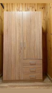 un armario de madera con 2 puertas en una habitación en Бабай Садиба, en Vasylʼkiv