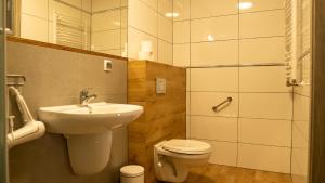 a bathroom with a sink and a toilet and a shower at Ośrodek LZS CIS "Od Nowa" in Mielno