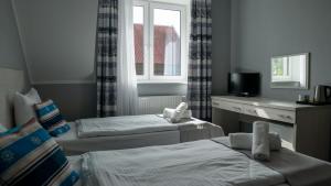 a hotel room with two beds and a window at Ośrodek LZS CIS "Od Nowa" in Mielno