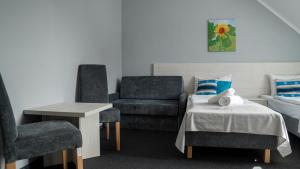 ミエルノにあるOśrodek LZS CIS "Od Nowa"の椅子2脚、ベッド1台、テーブルが備わる客室です。