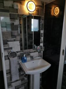 a bathroom with a sink and a mirror at TD Guest House 4 Plus in Chimoio