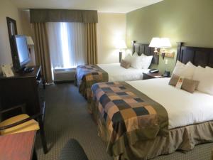 a hotel room with two beds and a television at Wingate by Wyndham in Peoria