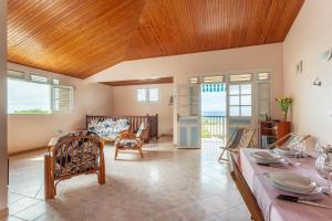 ein großes Wohnzimmer mit Holzdecke in der Unterkunft Villa Yayanne in Les Anses-dʼArlets