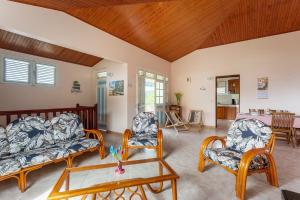 Villa Yayanne في لو أنسيه دو أرليتز: غرفة معيشة مع كراسي وطاولة