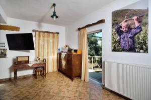 Villa Areti - A Cottage in the Cretan Nature في Kántanos: غرفة معيشة فيها لوحة رجل معلقة على الحائط