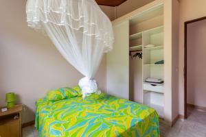ein Schlafzimmer mit einem Bett mit Vorhang darauf in der Unterkunft Villa Yayanne in Les Anses-dʼArlets