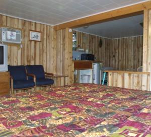 a bedroom with a bed and two chairs at Antler Motel in Greybull