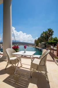 una mesa blanca y sillas en un patio con agua en Port Alacati Hotel, en Alacati