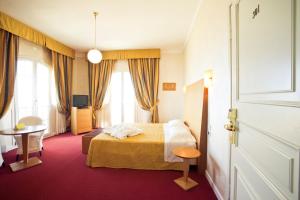 a hotel room with a bed and a window at Grand Hotel Cesenatico in Cesenatico