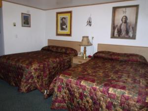 Habitación de hotel con 2 camas y una foto en la pared en Antler Motel en Greybull