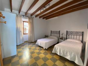 a bedroom with two beds in a room with a window at casa nuria, en el centro, al lado de la escalinata del calvario para 6 personas in Pollença